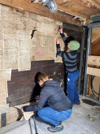 Mitarbeiterinnen des Amts für Denkmalpflege und Archäologie beim Ablösen von Notenblättern in einem Haus in Menzingen. Foto ADA ZG, Anette JeanRichard.