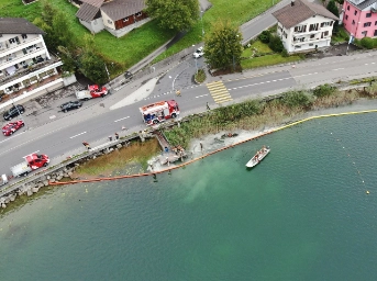 Feuerwehrleute richten Ölbarriere ein